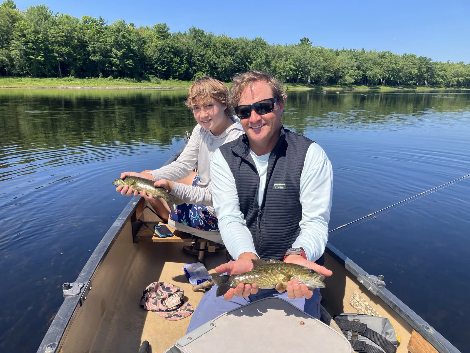 Adult and child holding a fish during a guided canoe fishing trip