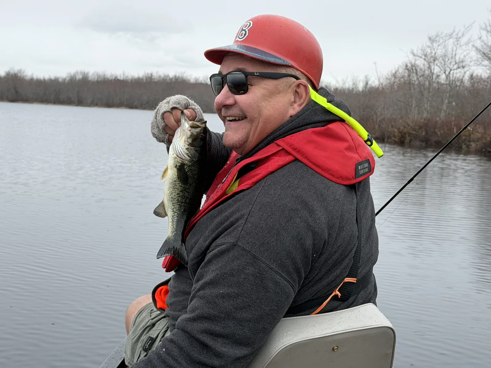 Client holding a fish during a cool-weather guided canoe fishing trip