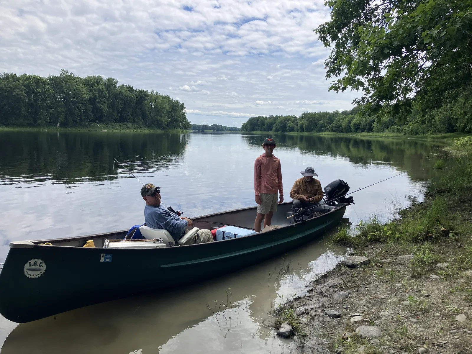 Group of clients in a canoe during a guided Maine fishing trip