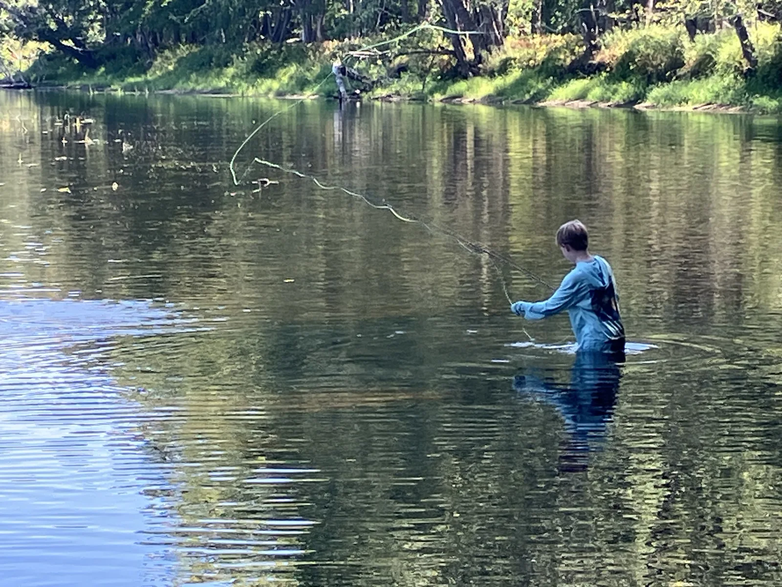Client fly fishing in a Maine river