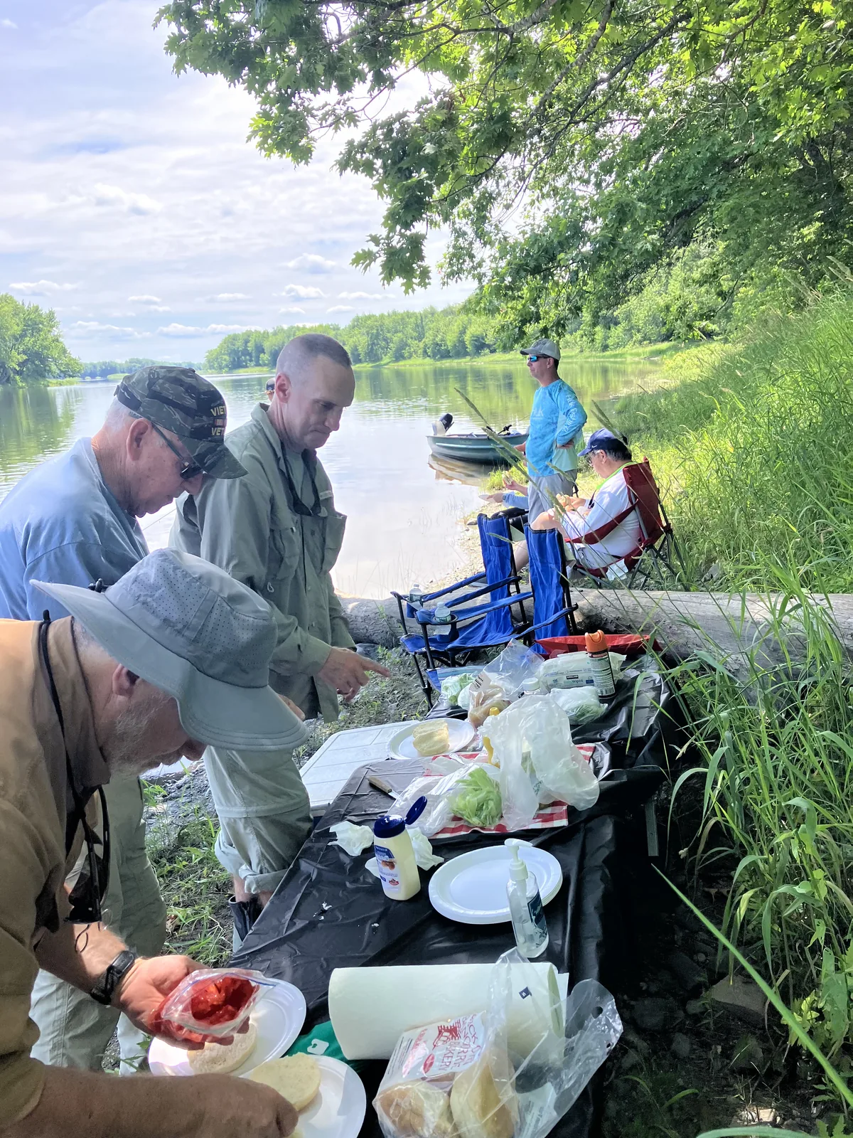 Clients gathered for shore lunch during a guided Maine river trip