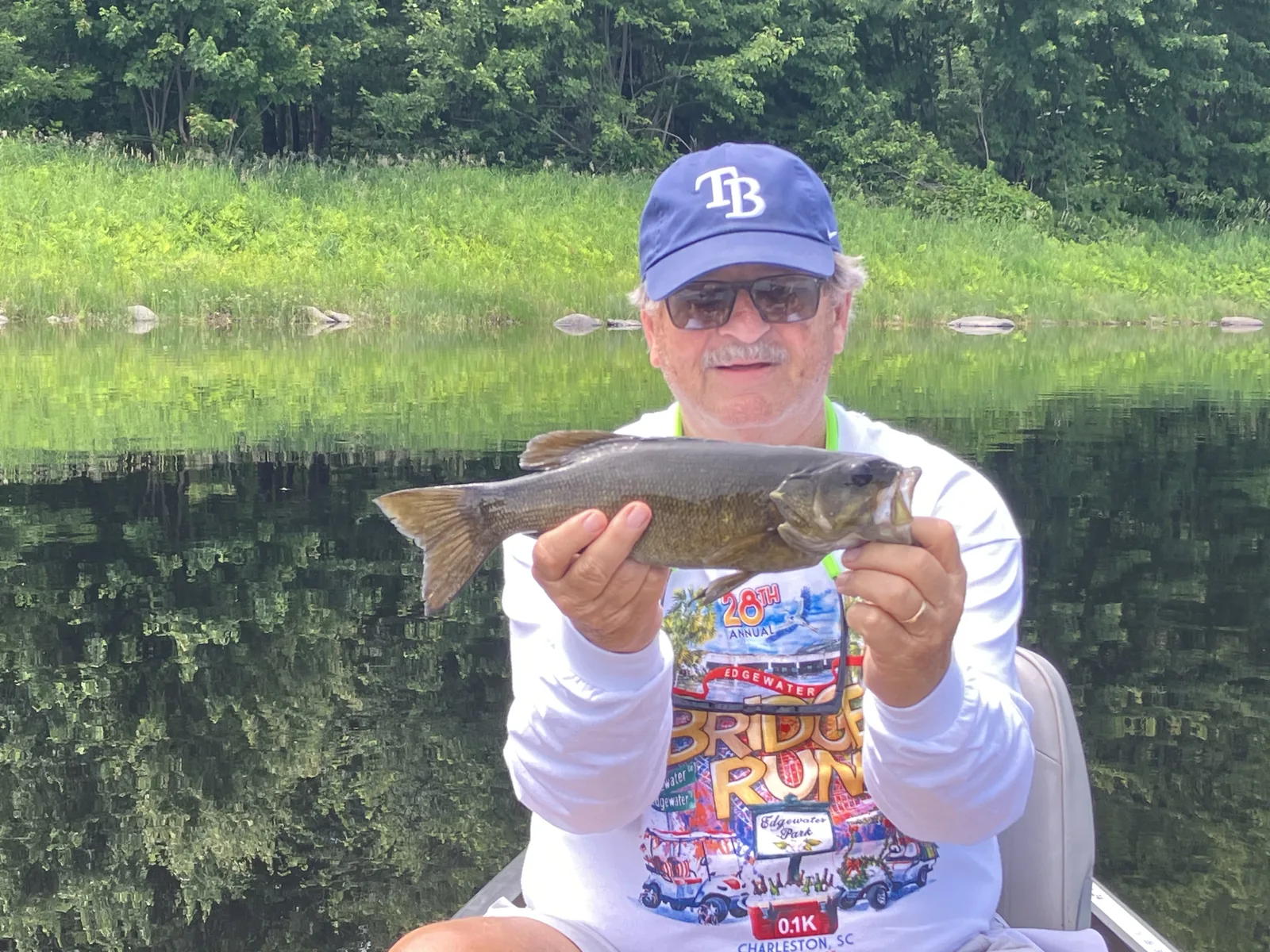 Client holding a smallmouth bass during a guided fishing trip in Maine