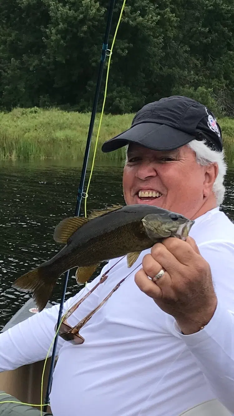 Client holding a smallmouth bass during a guided Maine fishing trip