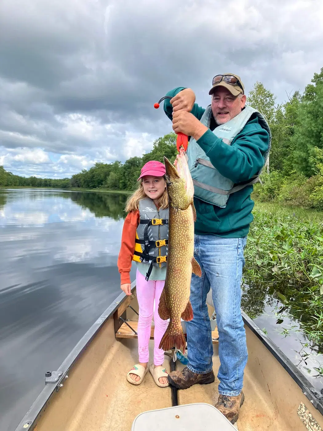 Family with a northern pike during a guided canoe fishing trip