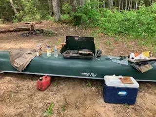 Canoe and shore lunch gear set up beside the water