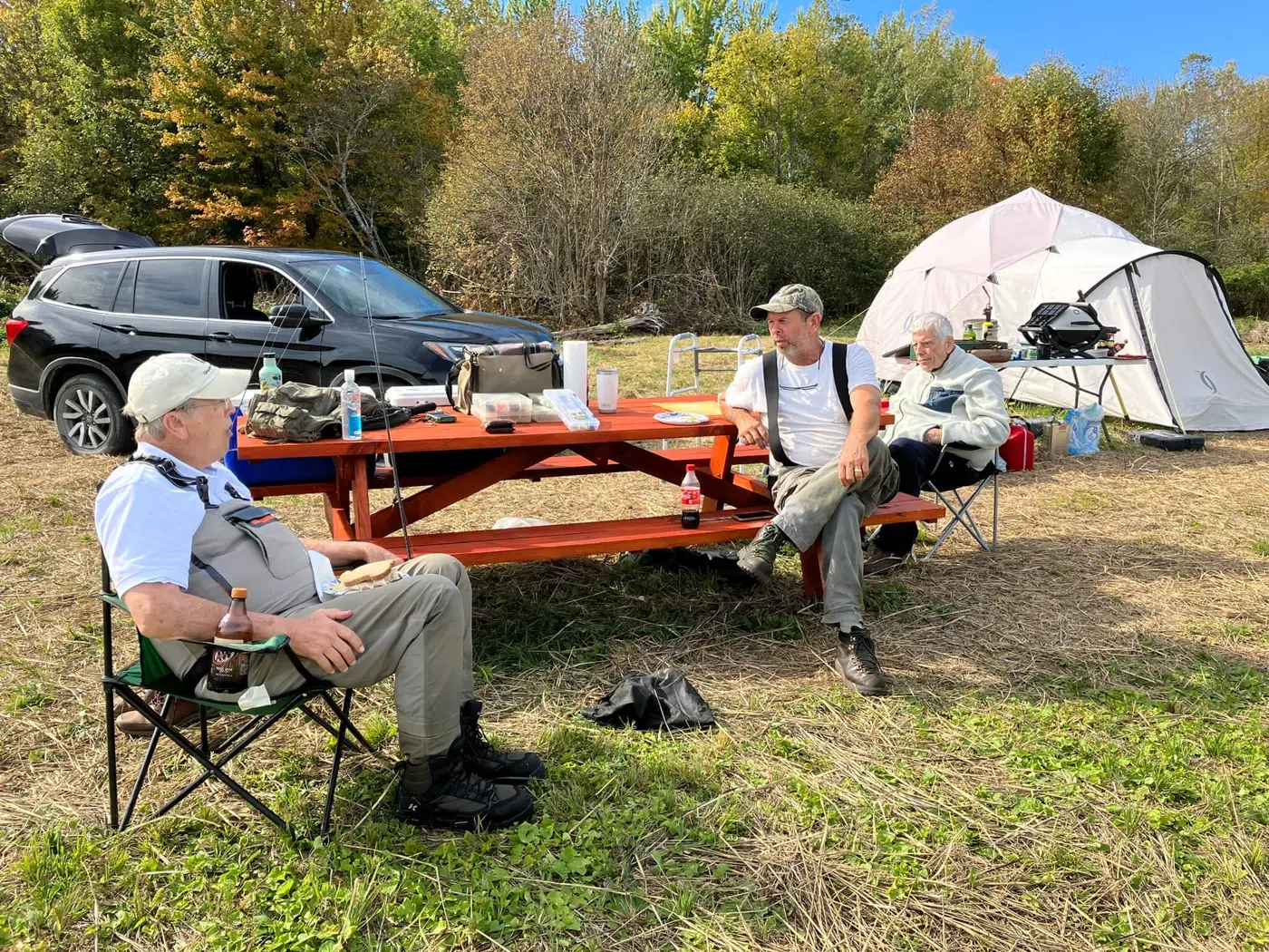 Clients gathered near canoes and a camp setup for shore lunch
