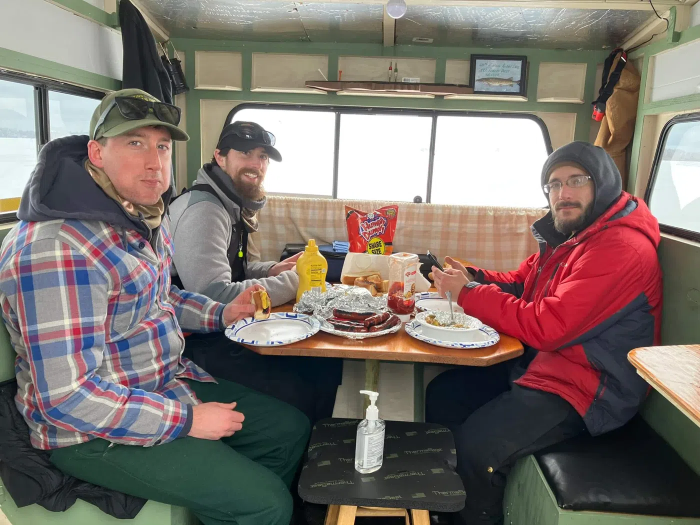 Clients sharing lunch inside an ice fishing shack