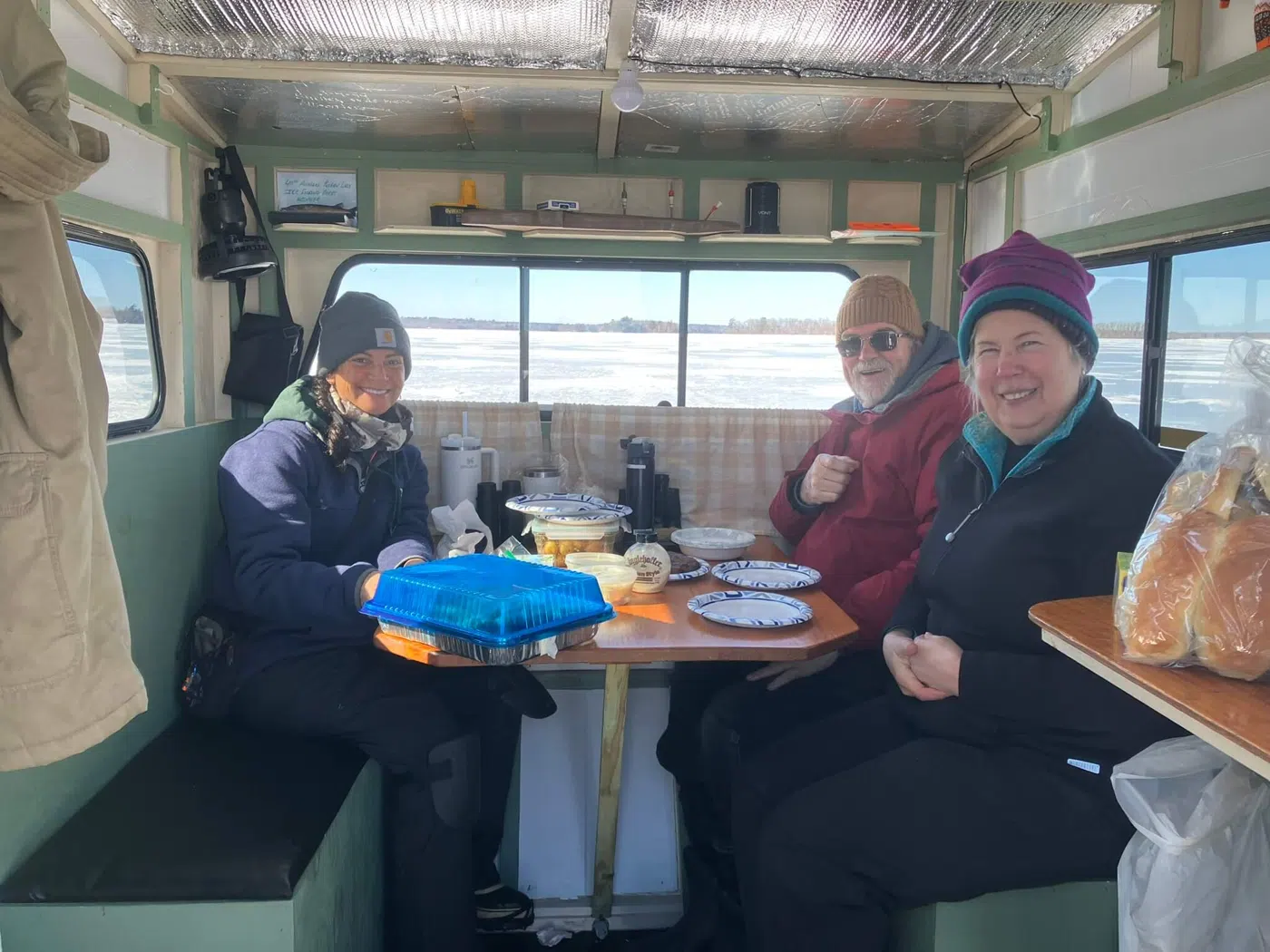 Clients eating lunch inside an ice fishing shack