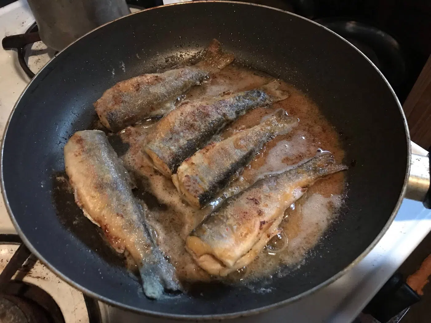 Fish cooking in a pan during shore lunch