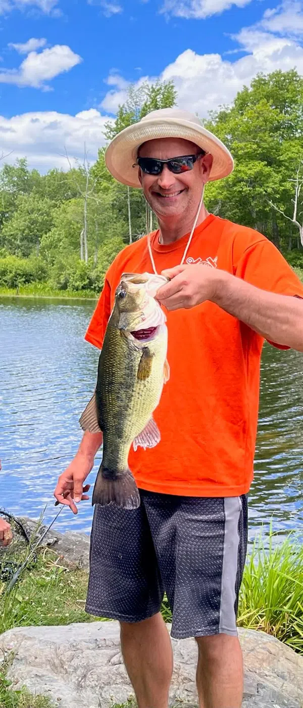 Young angler holding a bass during a guided fishing trip