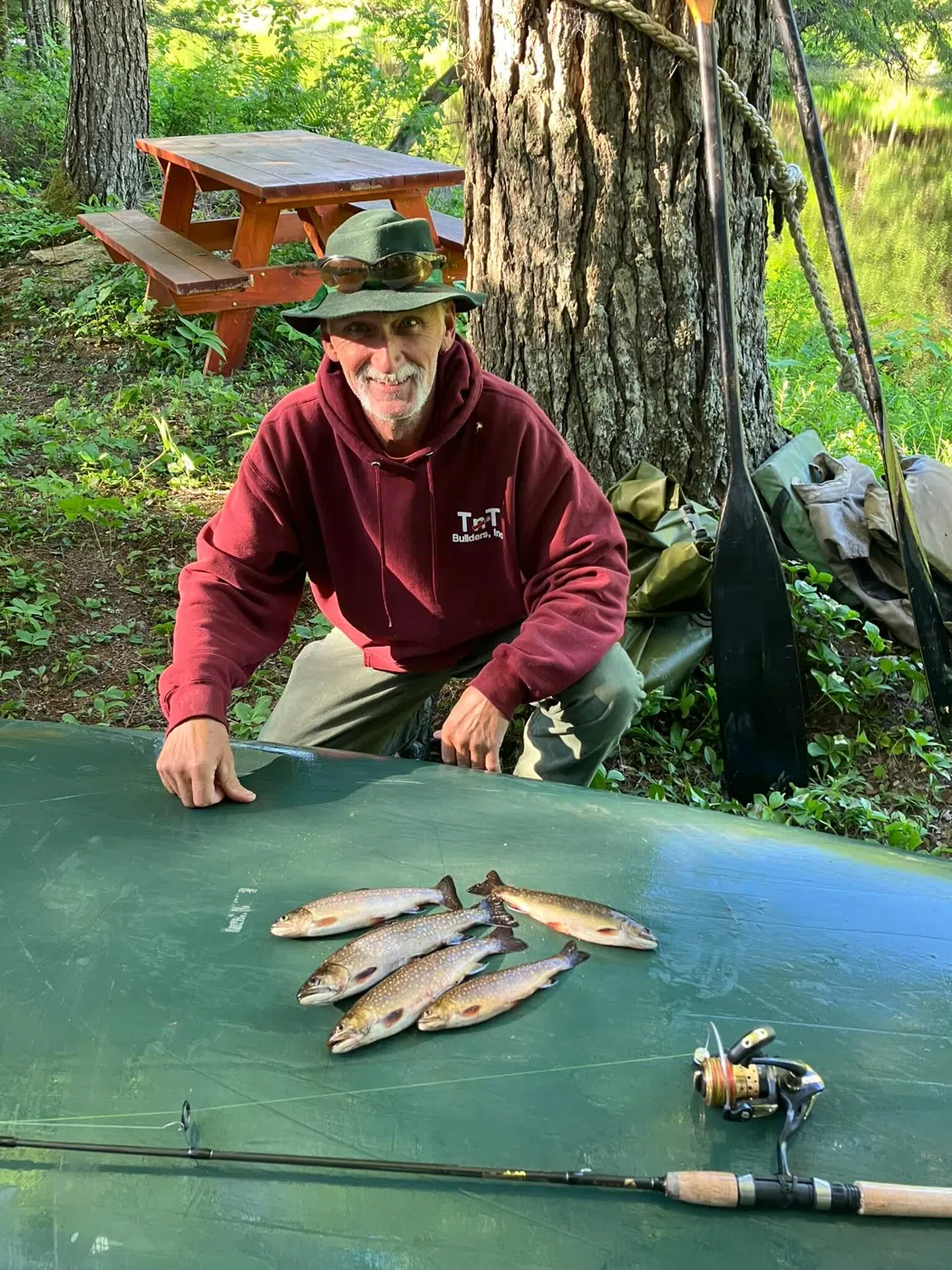 Client displaying fish on a table during a guided Maine trip