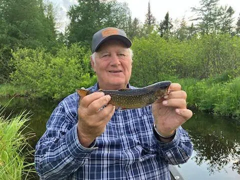 Client holding a small fish during a guided fishing trip