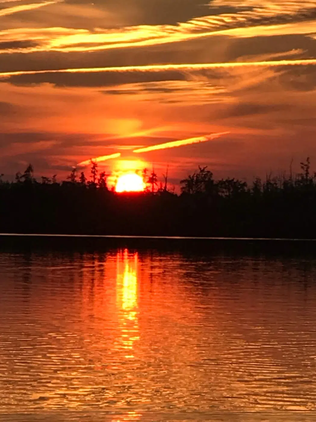 Sunset over calm water during a Maine outdoor trip