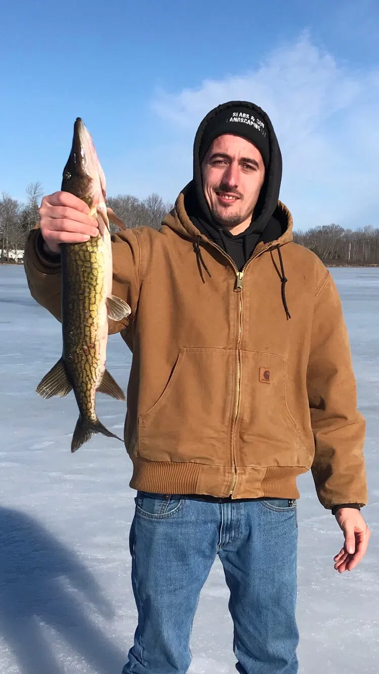 Client holding a fish during an ice fishing trip