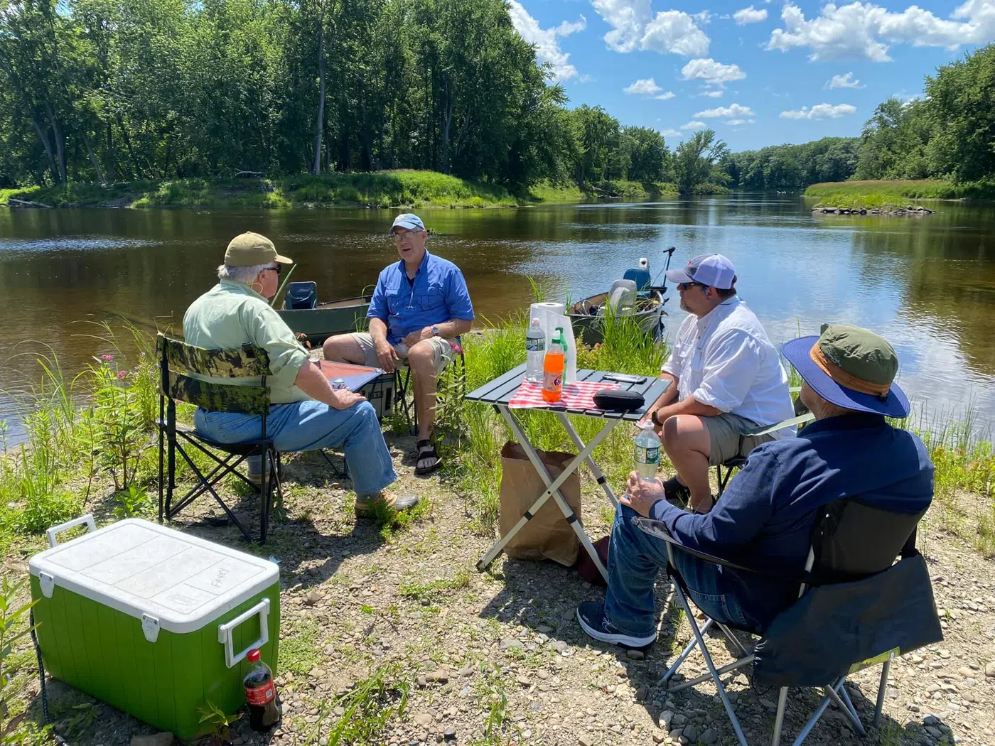 Clients gathered for shore lunch beside a Maine river