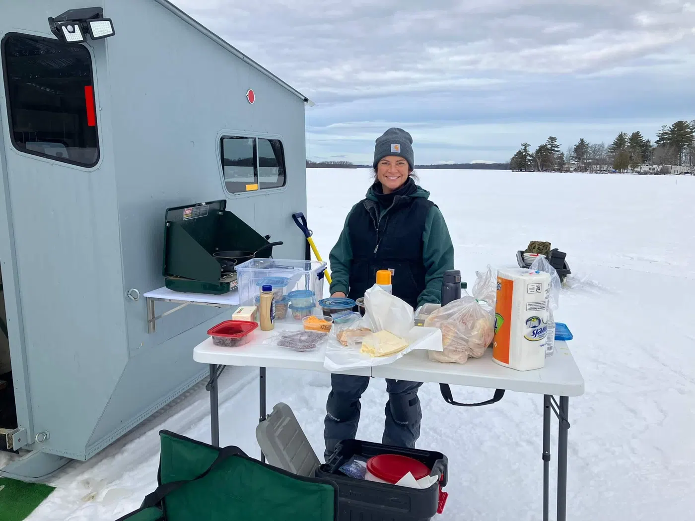 Ice fishing shore lunch setup beside a shack on a frozen lake