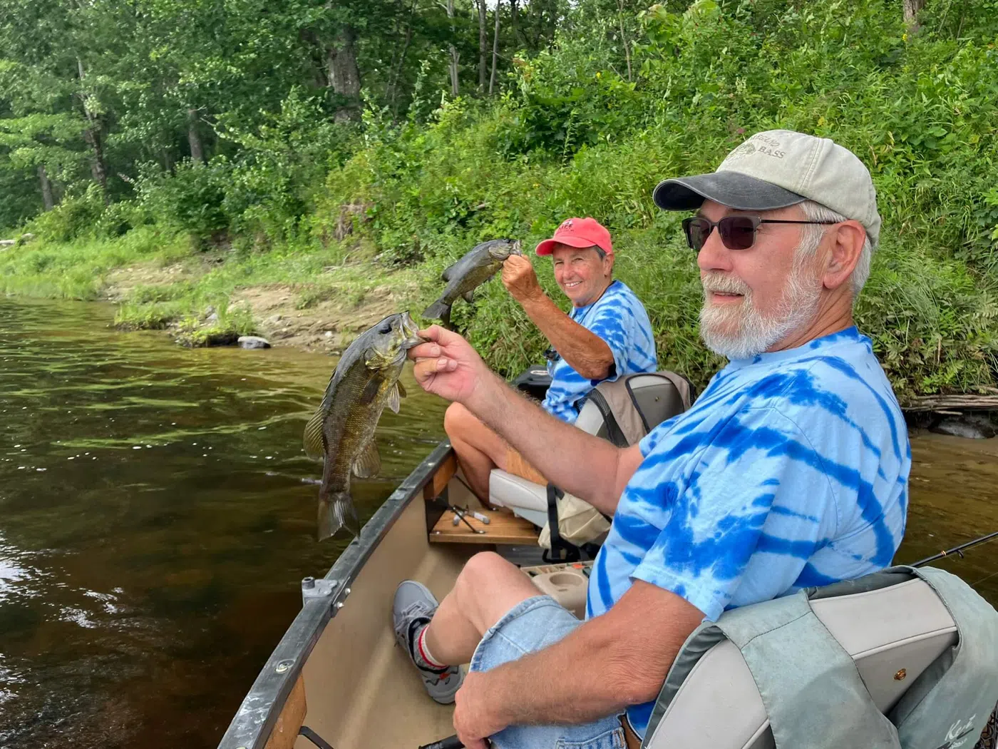 Clients fishing from a canoe during a guided Maine trip