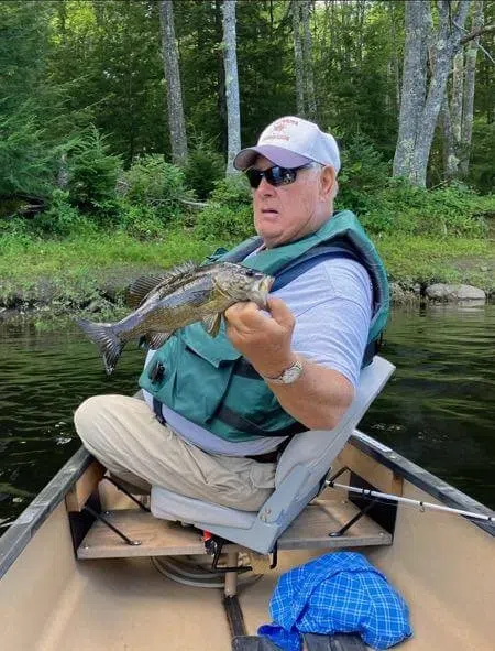 Client seated in a canoe during a guided fishing trip