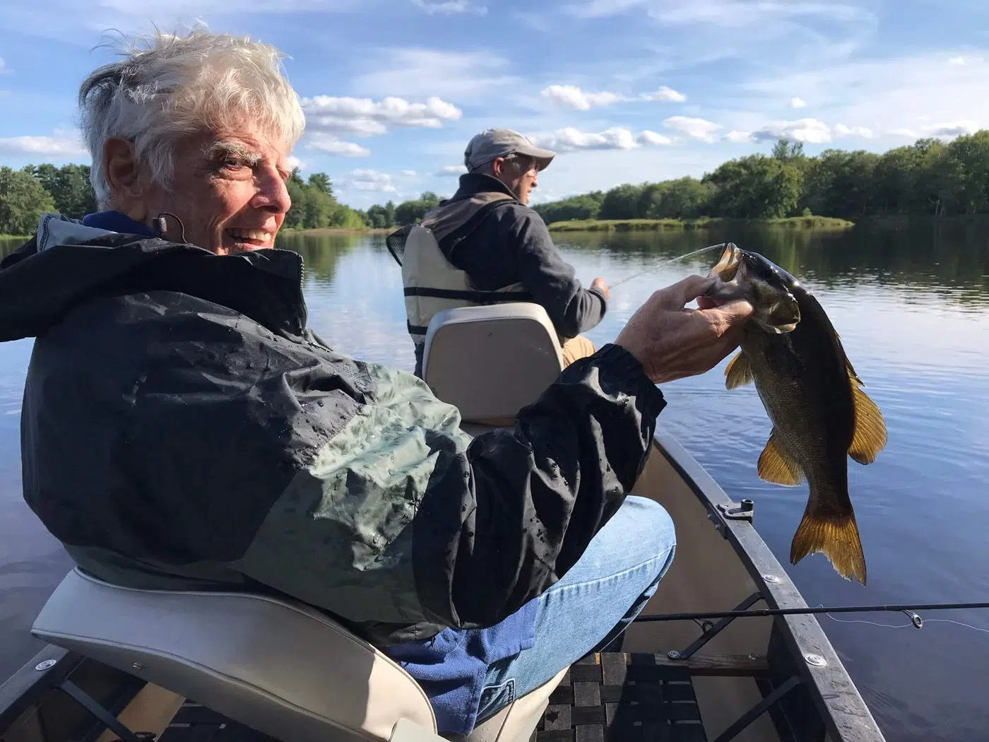 Client holding a fish from a canoe during a guided trip