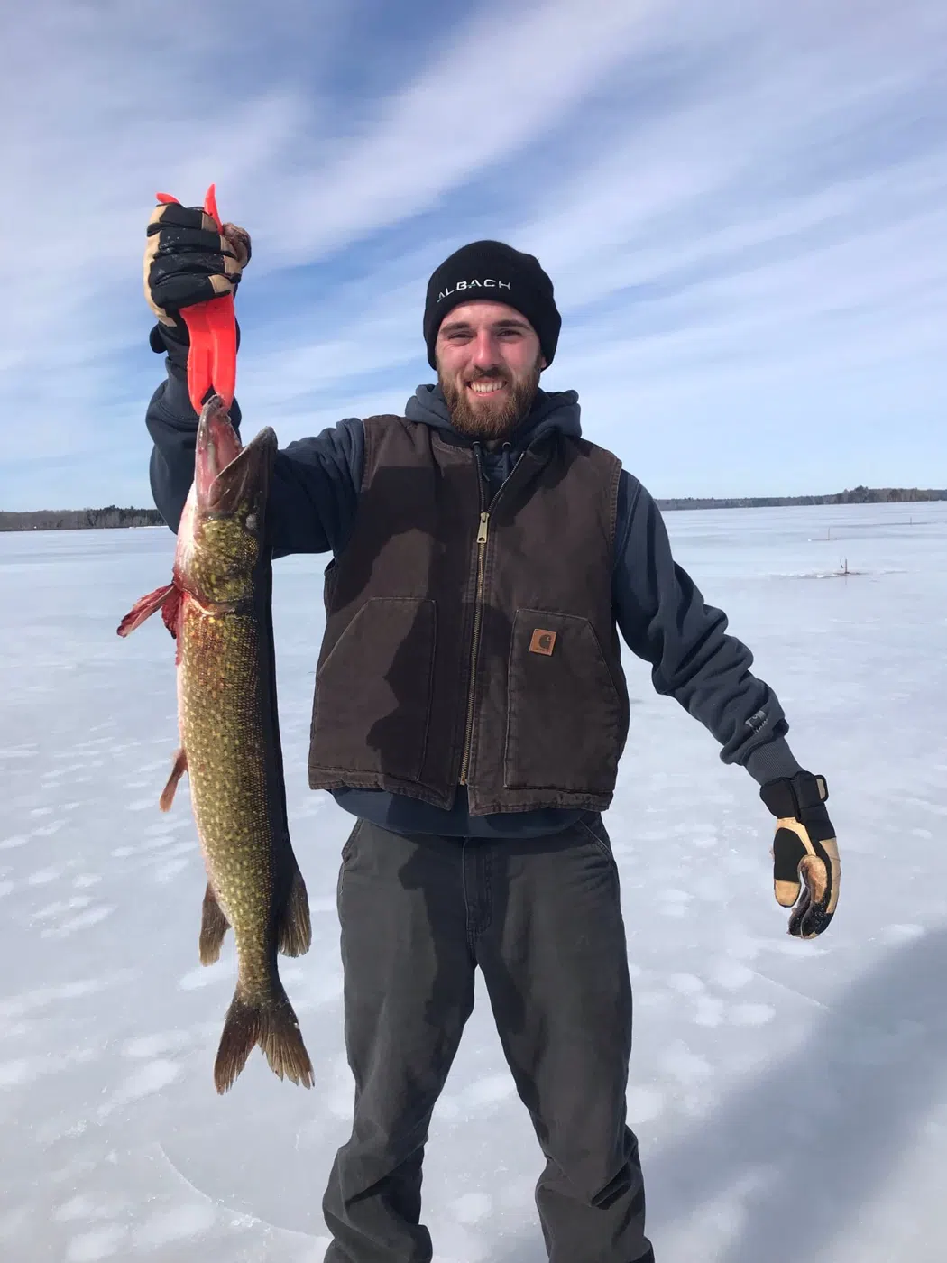 Client holding a fish during a Maine ice fishing trip