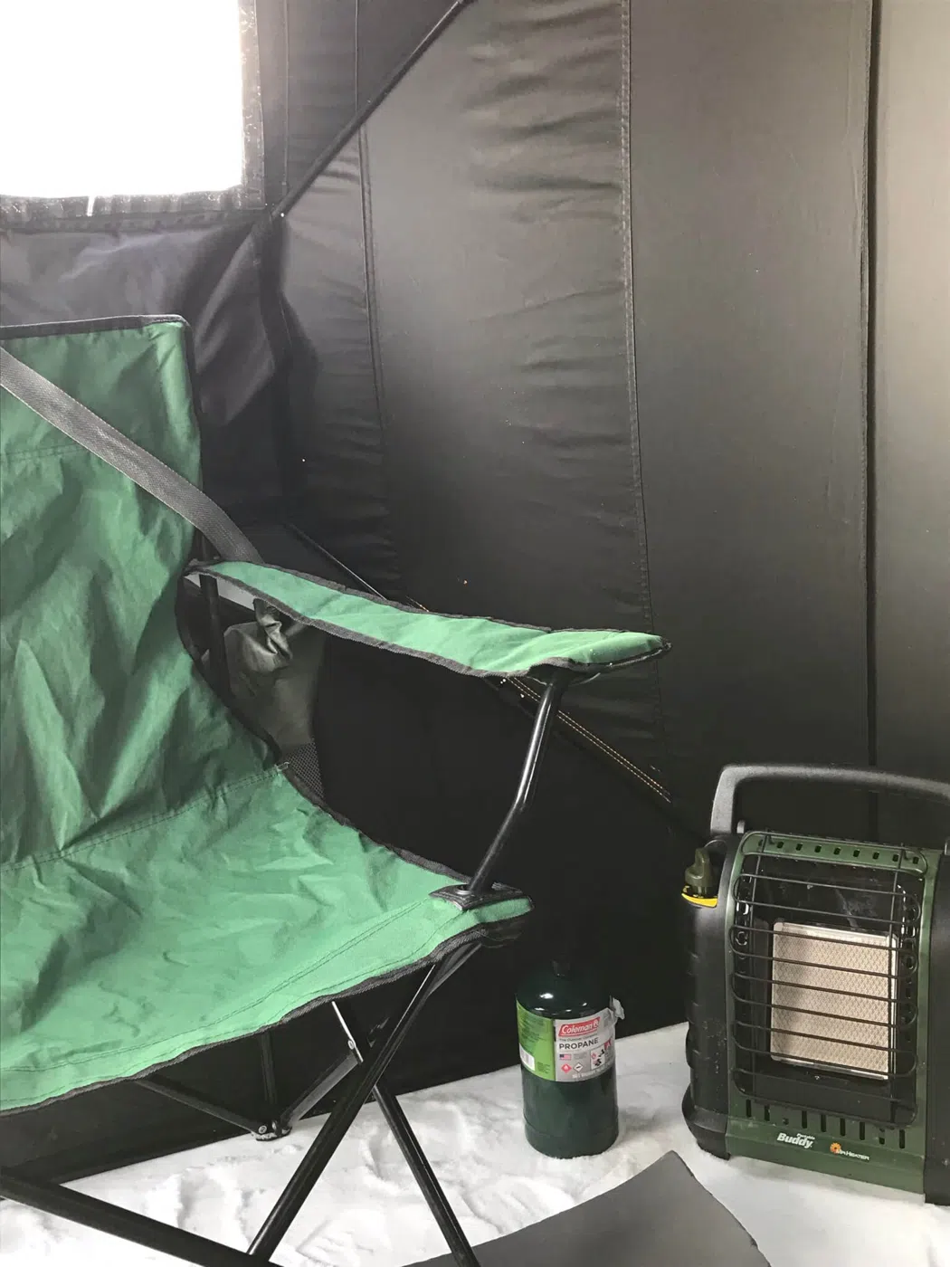Inside an ice fishing shack with heater and gear