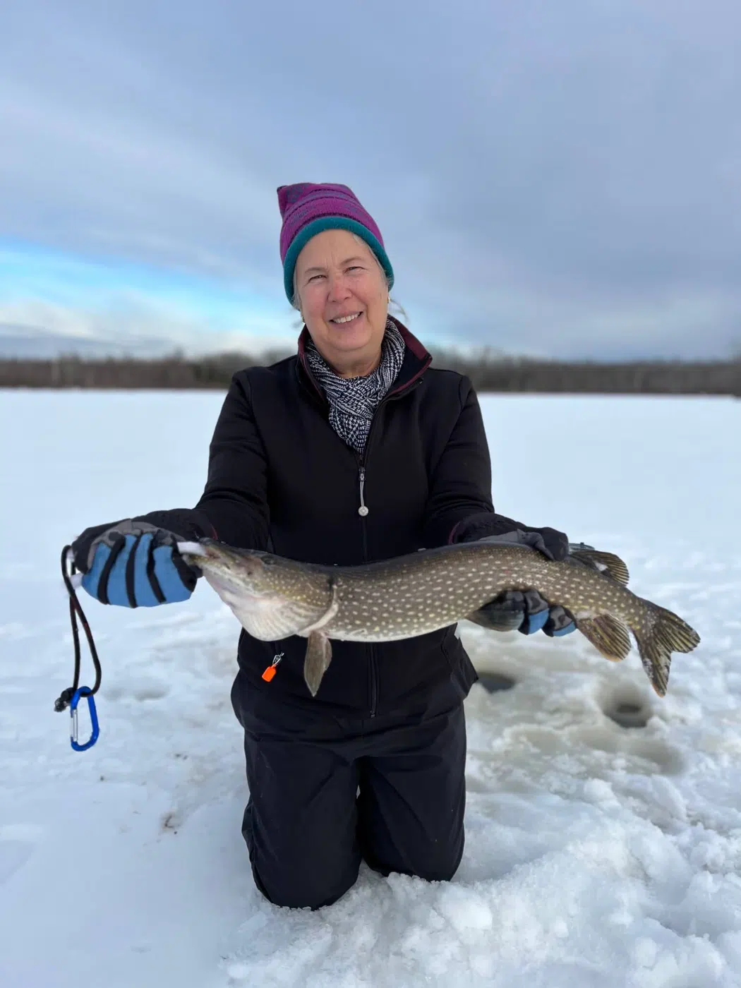Client holding a fish during a Maine ice fishing trip