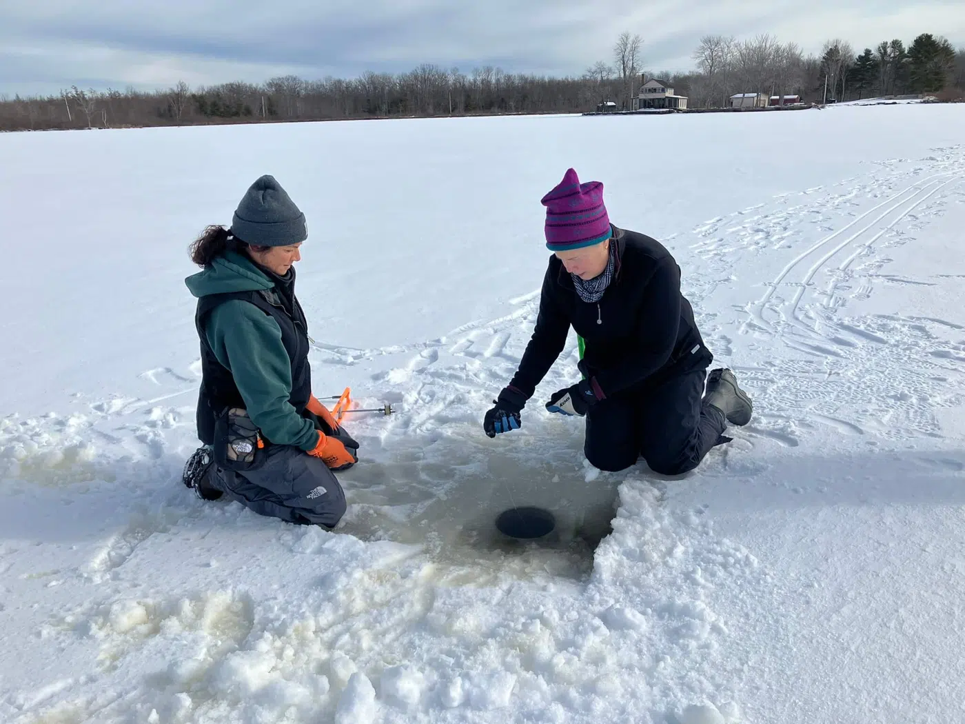 Ice anglers playing a fish through the ice